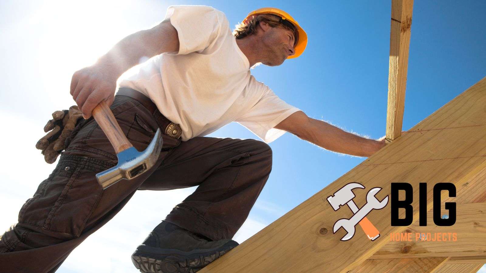 Roofer on a roof holding a hammer - bighomeprojects.com