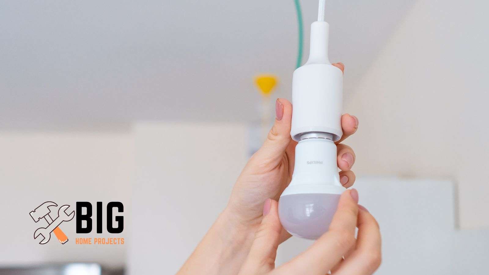 Person screwing on a more efficient light bulb - bighomeprojects.com