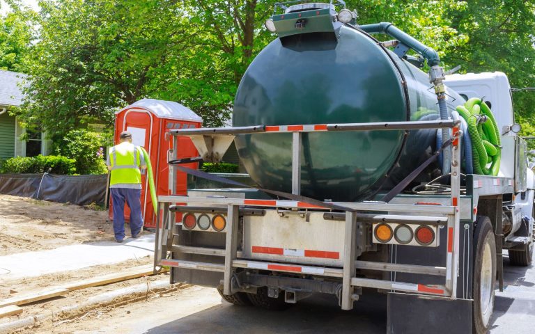 green septic truck and porta potty 768x480